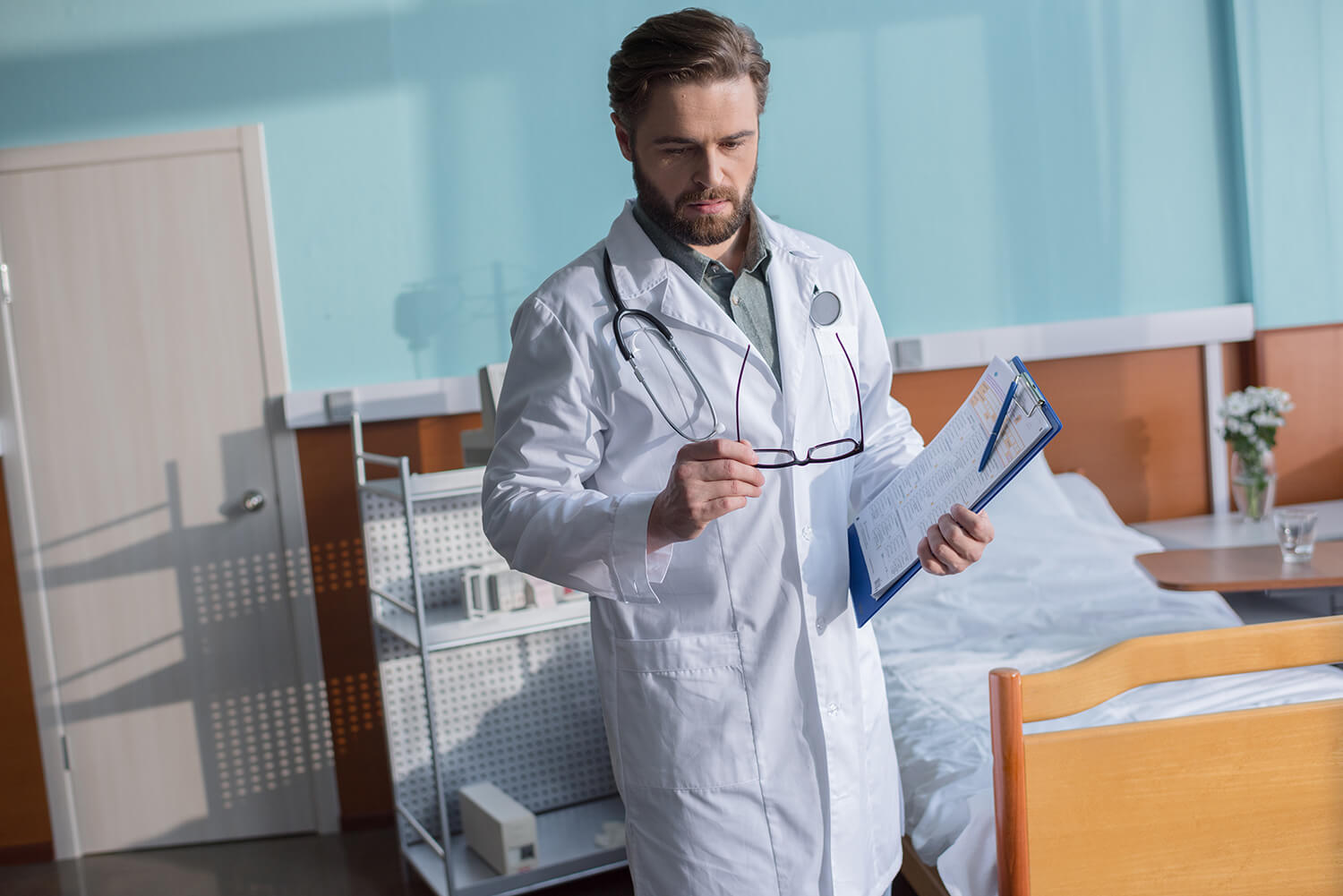 young-concentrated-male-doctor-with-stethoscope