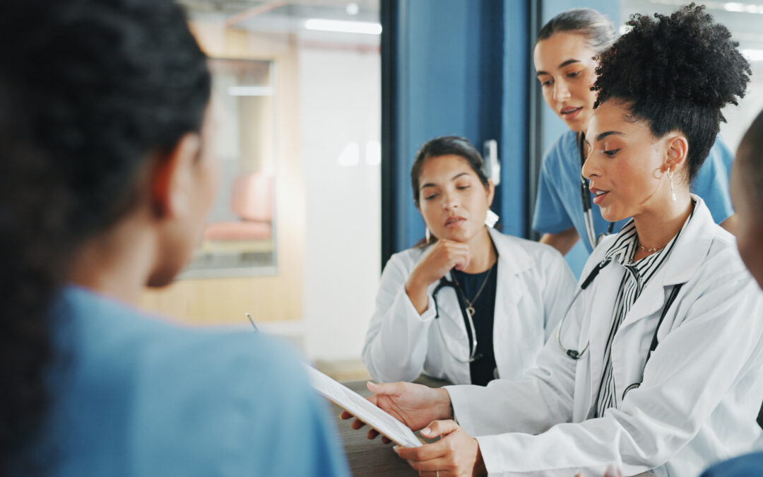 Physicians and nurses reviewing clinical documentation together in a medical practice meeting